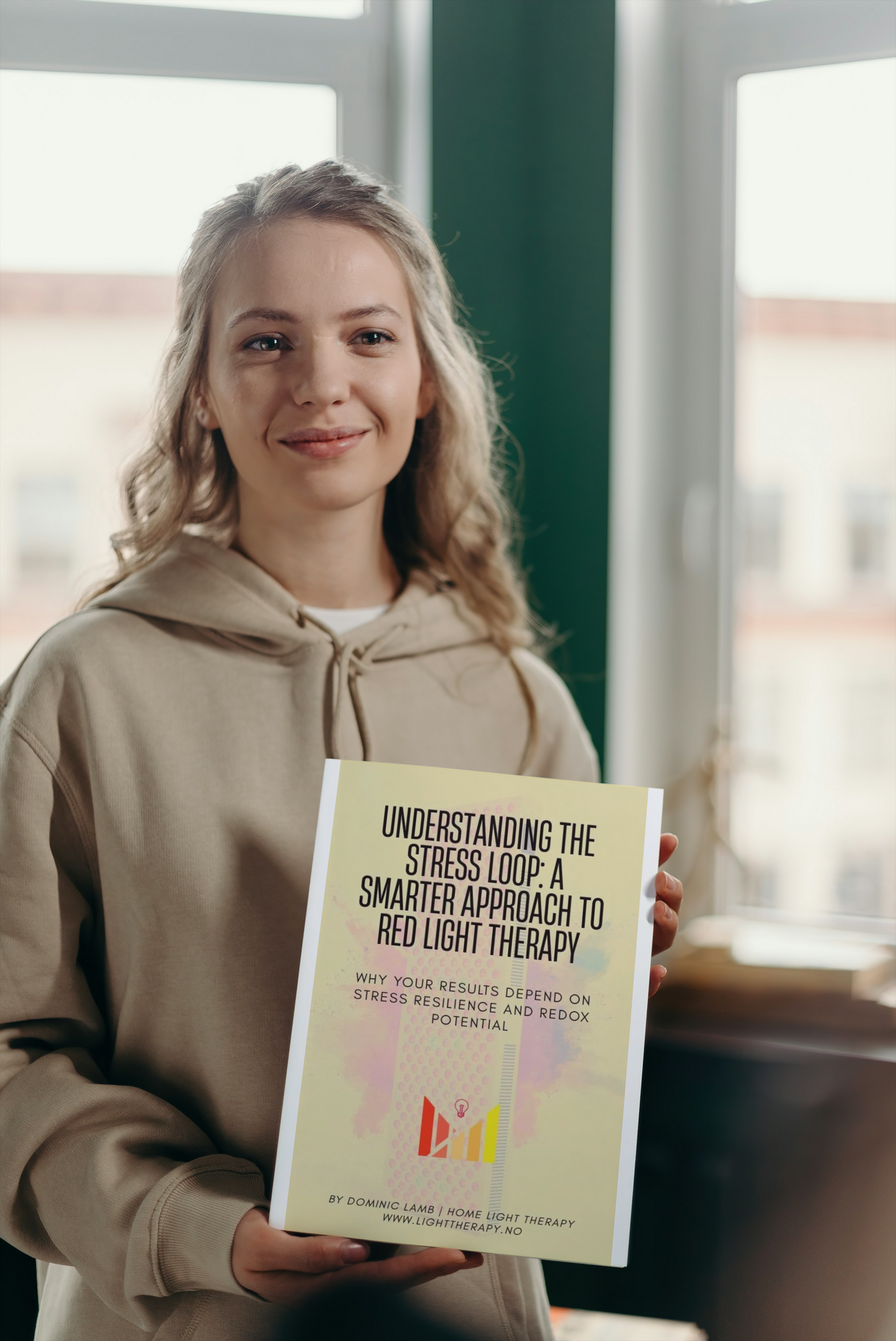 Woman holding a book titled 'Understanding the Stress Loop' in a room with large windows.