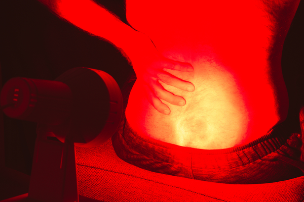 Red light therapy panel targeting lower back pain, photobiomodulation for spinal and muscle pain, LightTherapy.no Norway