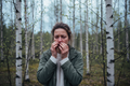 Person outdoors in Norwegian spring light with birch trees in background, red eyes, allergy season Norway 