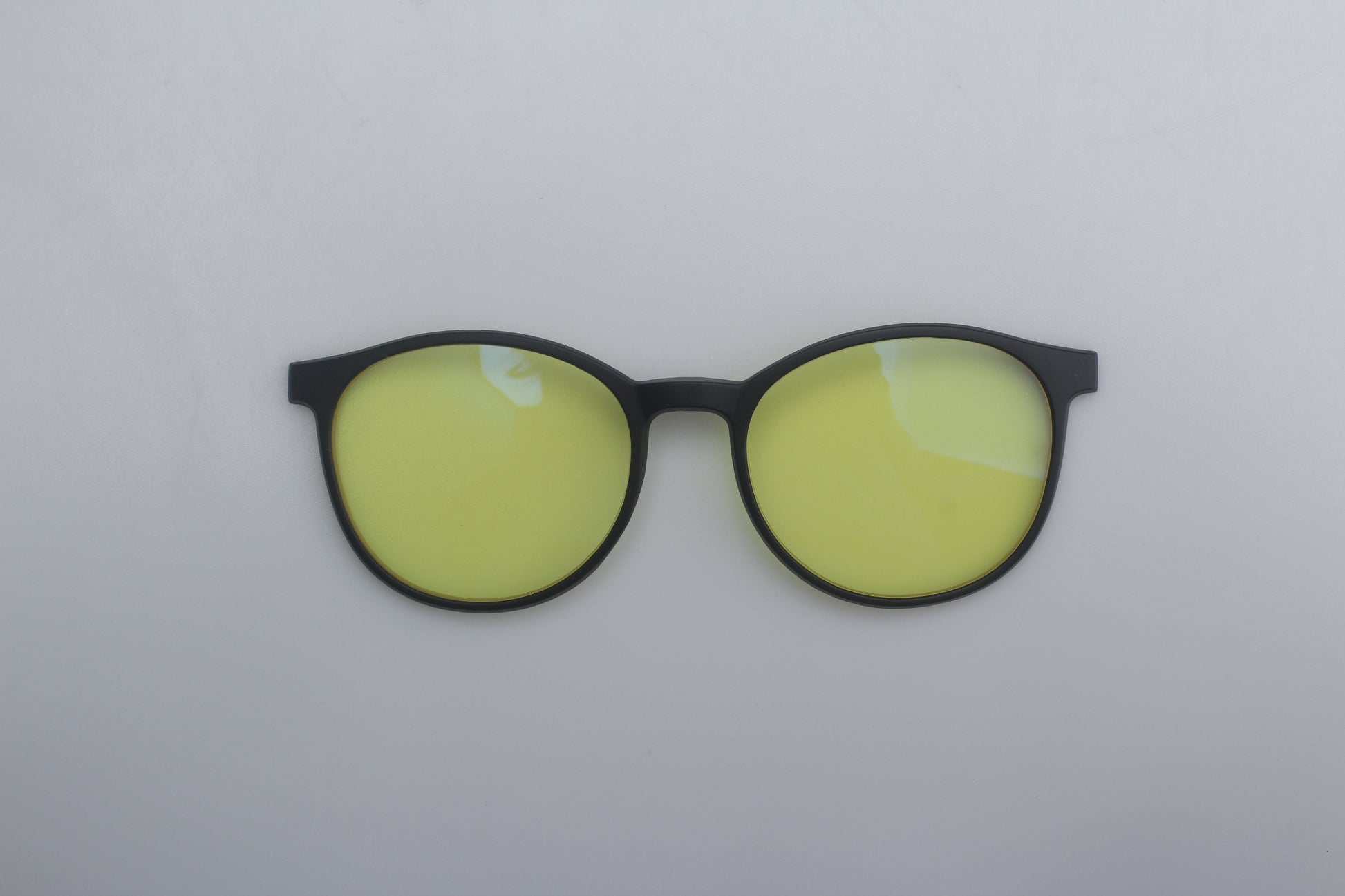 Round Blue blocking glasses with yellow lenses and black frames on a white background