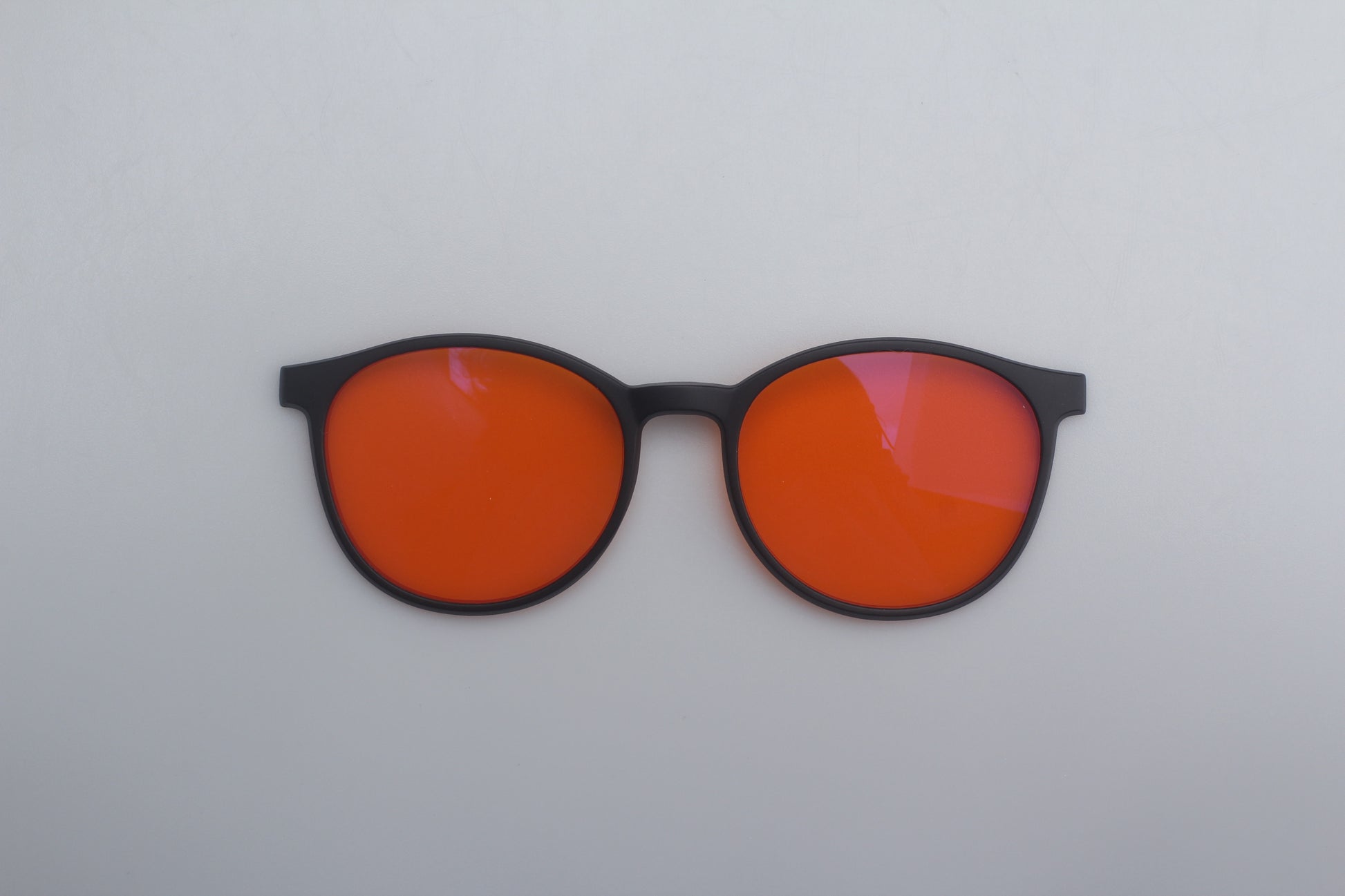 Blue Blocking glasses with orange lenses and black frames on a white background