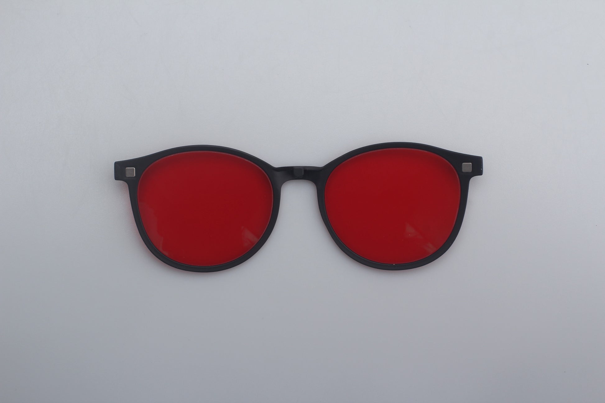 Glasseswith red lenses and black frames on a white background