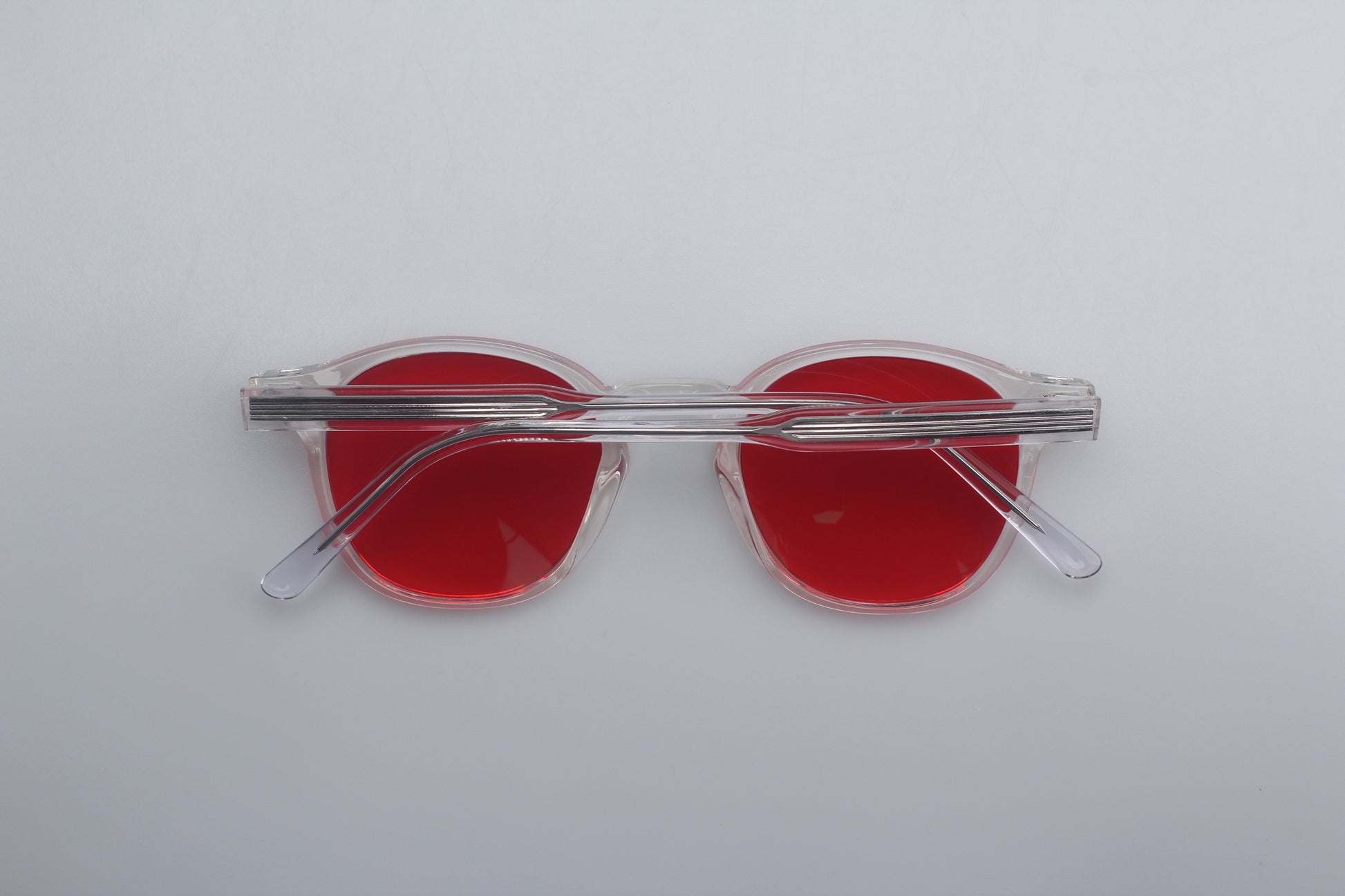 Blue Light blocking glasses (blålysbriller) with red lenses and clear frames on a white background