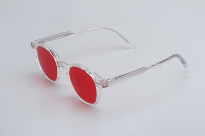 Clear frame Blue Light blocking glasses (blålysbriller) with red lenses on a light gray background