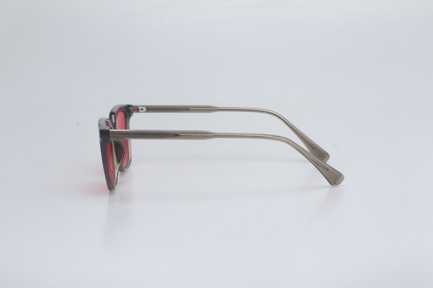 Blue light blocking glasses with red lenses and thin metal frame on a white background
