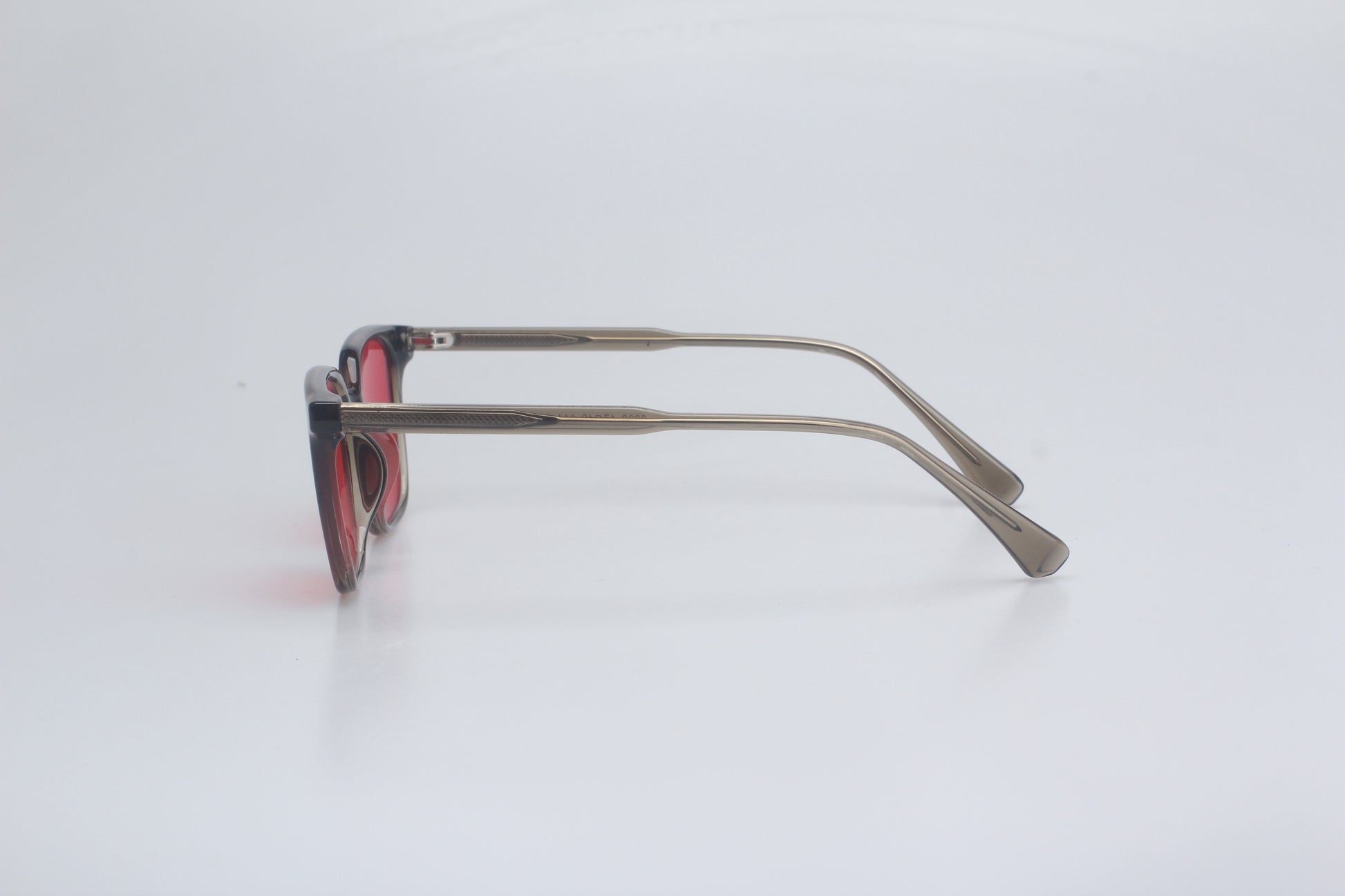 Blue light blocking glasses with red lenses and thin metal frame on a white background
