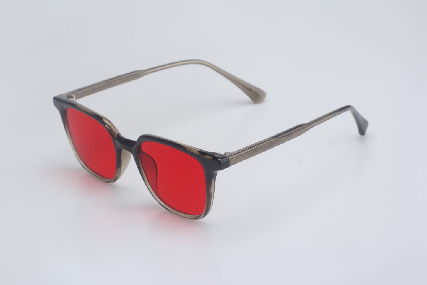 Blue light blocking glasses with red lenses and gray frames on a light gray background 