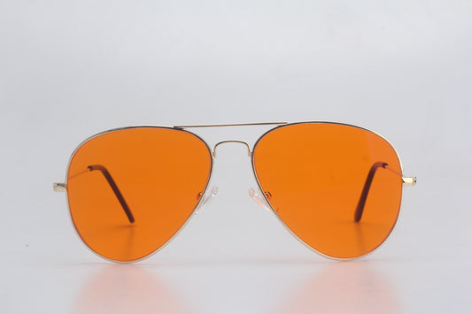 Aviator Blue Light blocking glasseswith orange lenses on a light gray background