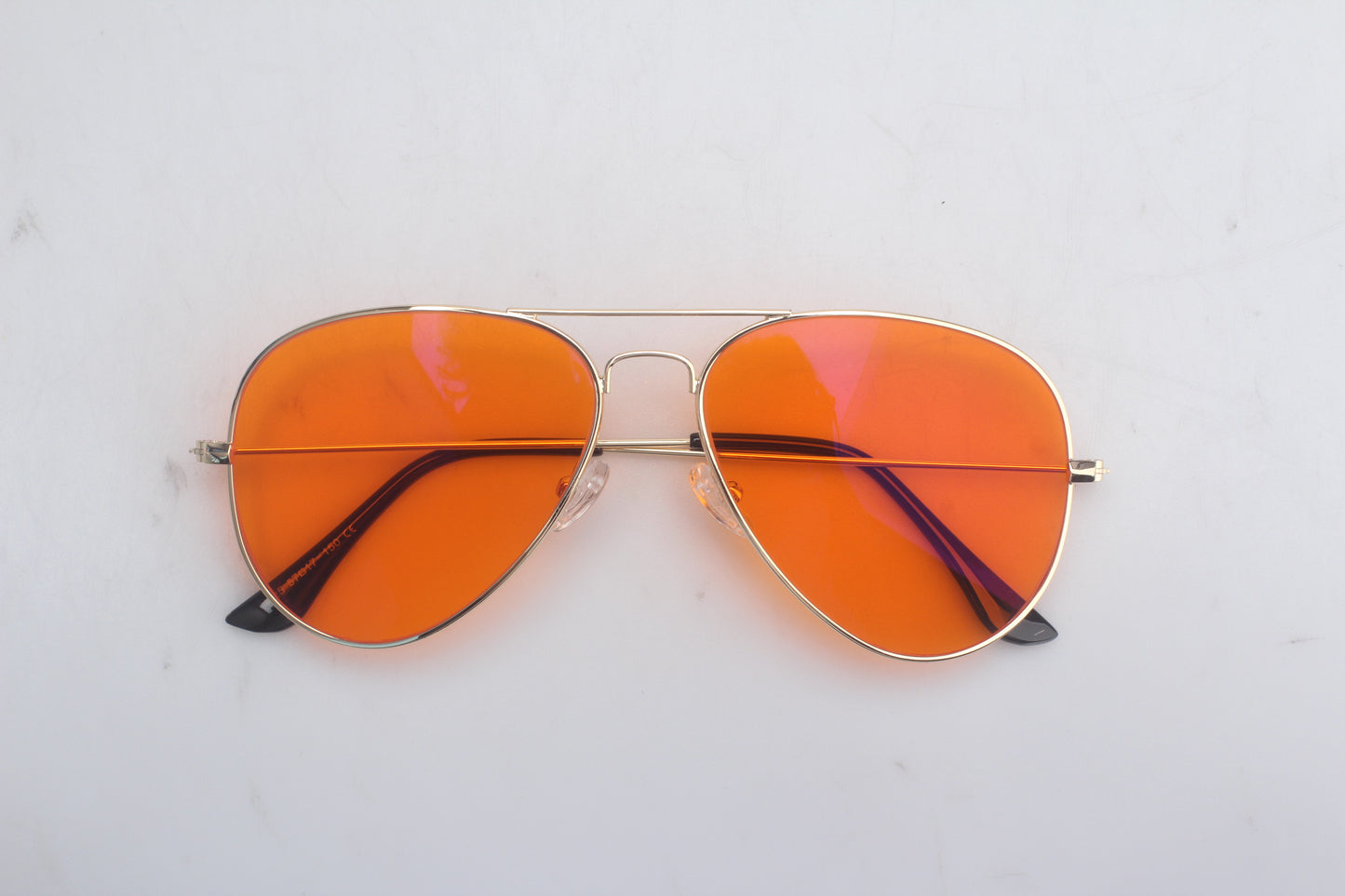 Aviator Blue Light blocking glasses with orange lenses and gold frame on a white background