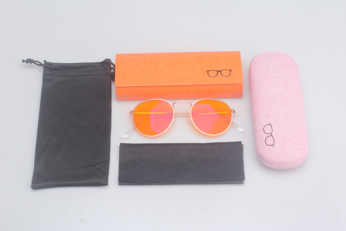 Set of Blue Light blocking glasses with accessories including a case, cleaning cloth, and packaging on a light gray background.