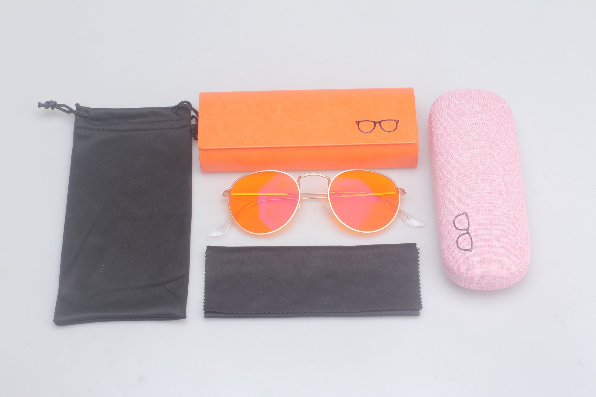 Set of Blue Light blocking glasses with accessories including a case, cleaning cloth, and packaging on a light gray background.