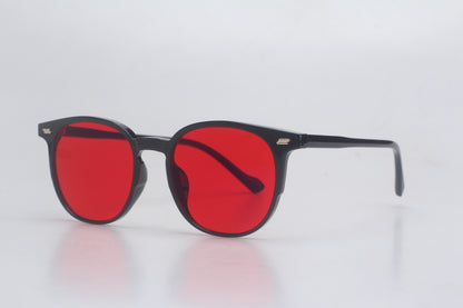 Blue Light blocking glasses with red lenses and black frames on a light gray background