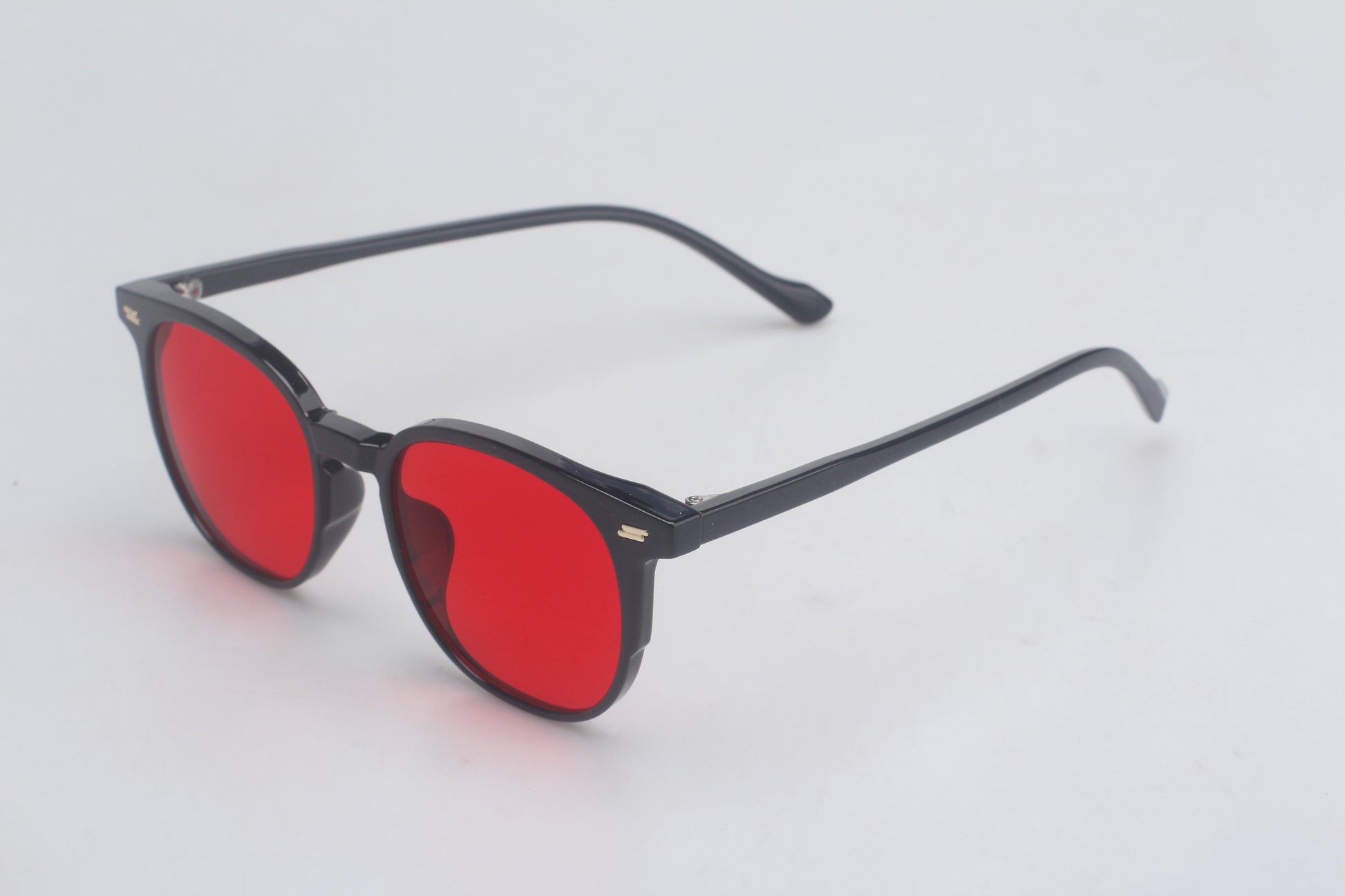Blue Light Blocking glasses with black frames and red lenses on a light gray background