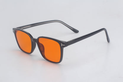 Blue Light blocking glasses with orange lenses and black frames on a light gray background