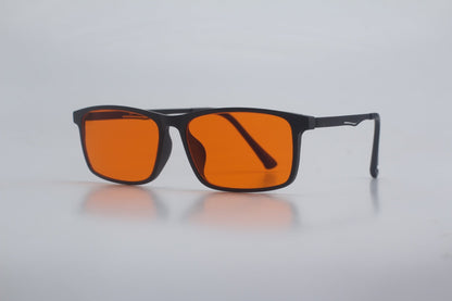 Sunglasses with orange lenses and black frames on a light gray background